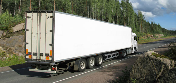 A semi truck driving down the road.